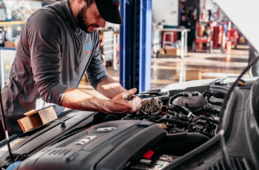 Man inspecting inside hood of car.