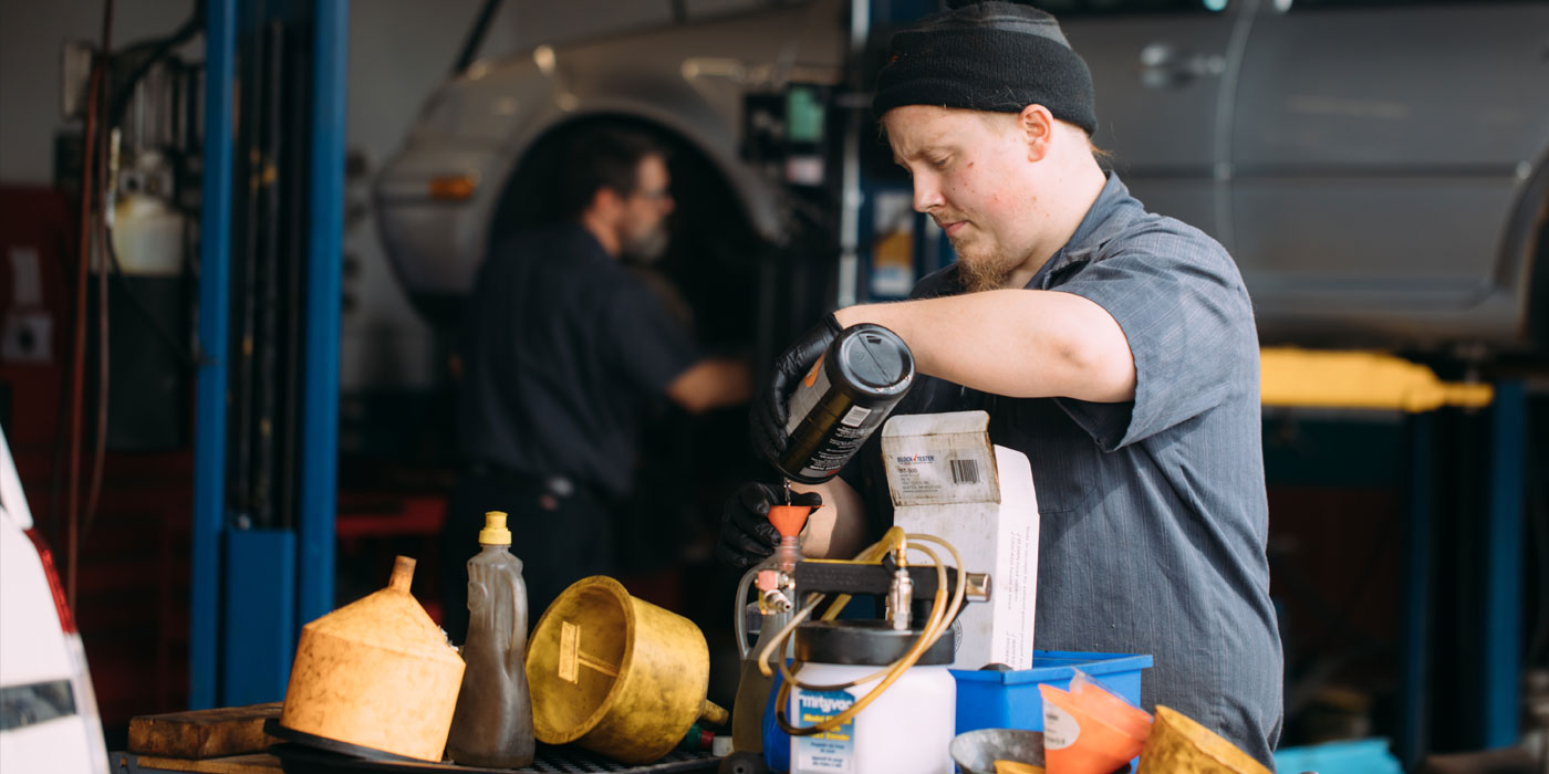Man working with oil in garage.