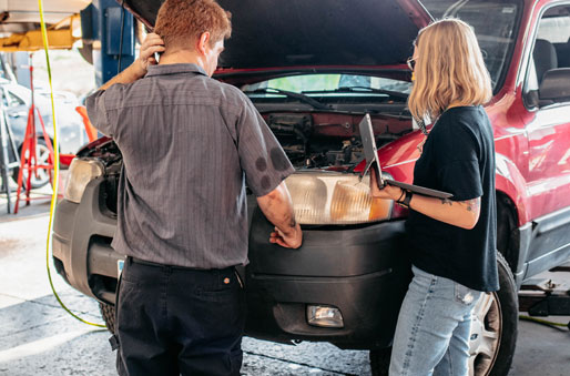 Two Lift Garage employees inspecting vehicle in a garage.